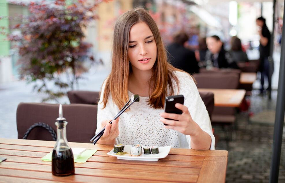 The girl, who is distracted during the meal, eats more than she needs